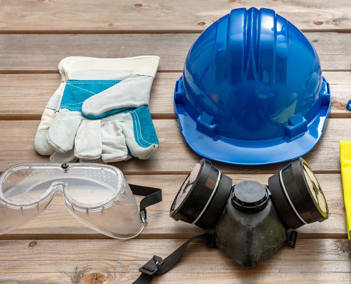 Work safety protection equipment on wooden background.